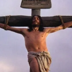 Jesus in a cloth around his waist crucified on a wooden cross.